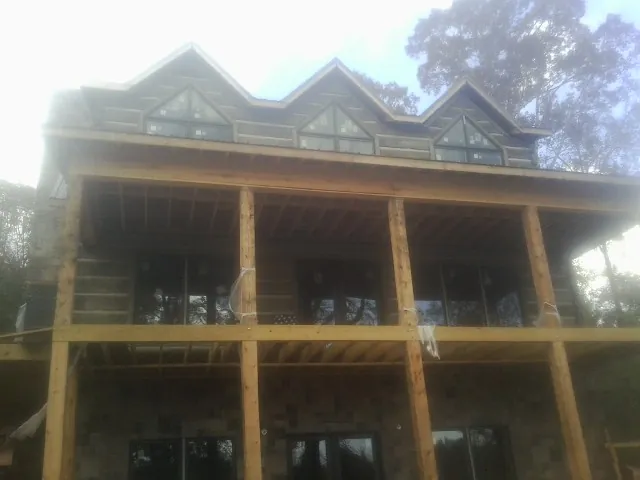 Dormers and porch framing on a large log home under construction — Roof Coating work by our crew in Payson